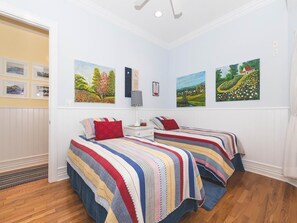 Bright and airy bedroom with large windows and two twin beds.
