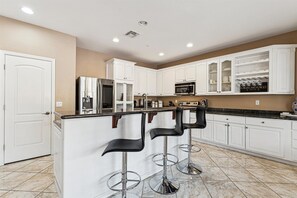 Fully equipped kitchen with stainless steal appliances and a kitchen island with bar seating for 3 guests.