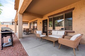 Private Backyard featuring a patio with outdoor seating, dining area with seating for 5 guests, and a grill.