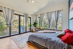 Bright and airy primary bedroom with large windows and blackout curtains for ultimate comfort.