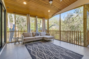 Relax in this outdoor retreat with a TV, ceiling fan, and fresh air.