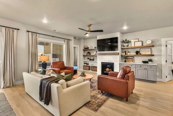 Step into a warm and inviting living space designed for relaxation and connection. This beautifully styled room features plush seating, a cozy fireplace, and a sleek smart TV—perfect for movie nights or unwinding after a day of adventure.