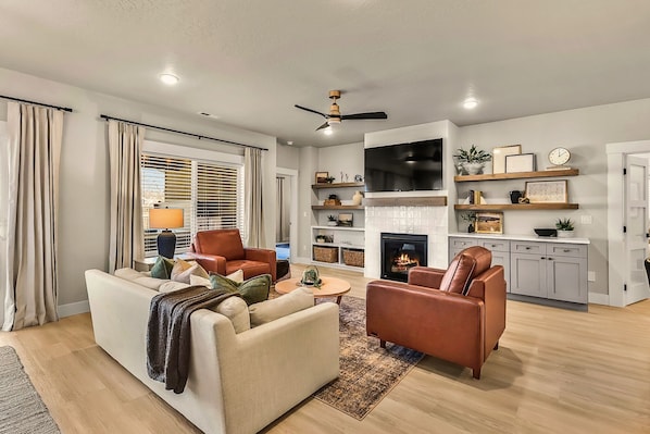 Step into a warm and inviting living space designed for relaxation and connection. This beautifully styled room features plush seating, a cozy fireplace, and a sleek smart TV—perfect for movie nights or unwinding after a day of adventure.