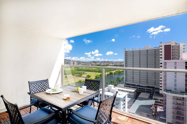 Have a nice meal with your loved ones on our spacious balcony featuring a dining table with four chairs, views of the Ala Wai Canal, and a partial ocean view (only visible between the buildings).