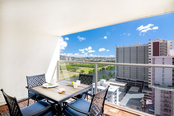 Have a nice meal with your loved ones on our spacious balcony featuring a dining table with four chairs, views of the Ala Wai Canal, and a partial ocean view (only visible between the buildings).