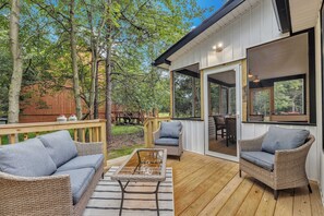 Relax in Style on the Deck – A serene outdoor seating area with comfortable wicker furniture, offering a perfect spot to unwind in the fresh air.