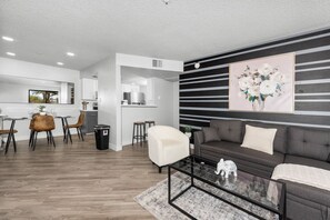 Bright, comfy living room with TV, sofa bed and dining area