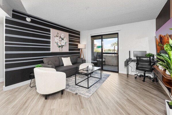 Bright, comfy living room with TV, sofa bed and deisgnated work station