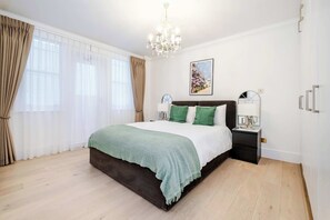 Luxurious bedroom with king bed, A/C & Smart TV for comfort and ease.