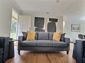 The living area features a 65-inch Samsung Smart TV with access to Netflix and other apps (cable and streaming services not provided). Relax on the sofa and chairs with convenient drink side tables.
