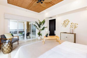 First bedroom with queen bed, pool view and terrace access.