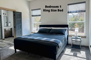 The spacious king bedroom has a smart TV, couple books and ceiling fan.