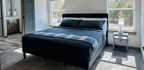 The spacious king bedroom has a smart TV, couple books and ceiling fan.