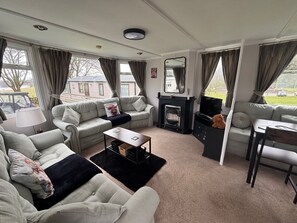 Bright living room with plenty of seating, TV and gas fire. 