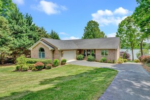 Welcoming entrance with lush greenery and clear lake views