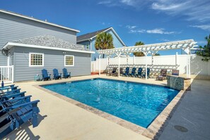 Sparkling community pool with loungers, picnic tables, and a grill—perfect for post-beach relaxation.