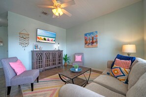 The living area features a coastal interior design and a sleep sofa for additional guests.