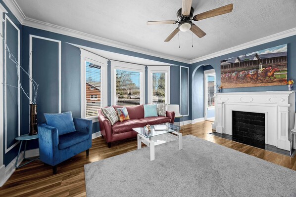 Living Room: Gather in this inviting living room with comfortable seating, a sleek red couch, and a flat-screen TV.