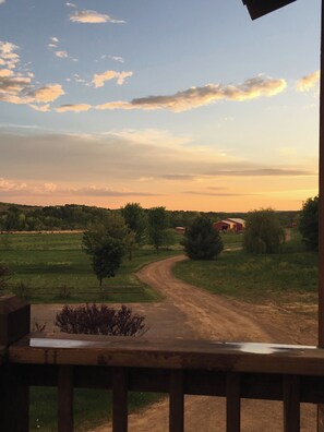 Sunset view during warm months from the veranda down the driveway to the barn.
