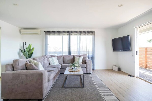 Sink into the L-shaped sofa and unwind with a movie on the wall-mounted TV in the air-conditioned living room.
