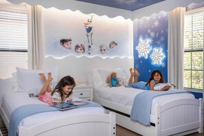 Cozy Disney-themed kids' room with twin beds, plush toys, and fun decor