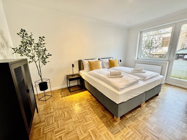 Master-Bedroom mit Kingsize-Boxspringbett und Zugang zum Balkon
