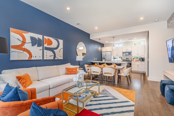 Bright open floor living space featuring a smart flat-screen TV, comfortable furnishings, and access to the outdoor patio. (2nd Floor)