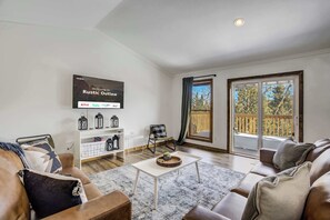 Relax in style with a spacious living area, Smart TV for entertainment, and direct access to fresh mountain air on the deck.