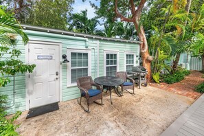 Quaint outdoor area with grill and dining set