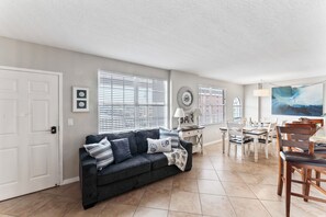 The living room area offers a versatile space with a comfortable queen-size sofa bed, providing both relaxation and additional sleeping accommodations for your convenience. 