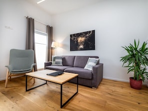 Furniture, Interior Design, Flooring, Couch, Floor, Wood Flooring, Wall, Wood, Living Room, Room