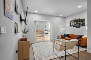 Step into the inviting open-concept living space, flooded with natural light. The contemporary mcm decor plush couch is perfect for relaxing after a day of exploring. Relax and enjoy listening to some Vinyl while you stay here! 