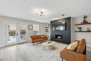 This spacious living area was designed to create great memories with family and friends with two sectionals, a wall-mounted TV, and French patio doors that lead to the backyard.