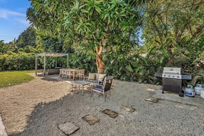 Fire up the grill and enjoy a backyard built for unforgettable gatherings! This lush outdoor space features a shaded lounge, dining area, and plenty of greenery, creating the perfect setting for cookouts