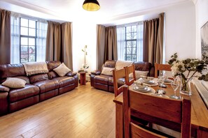 Livingroom with dining area, smart TV and leather sofas.