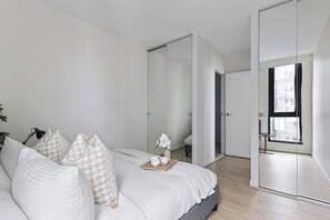 The master bedroom with a queen sized bed & plush pillows.