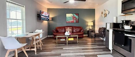Relax in a stylish lounge with a smart TV, full kitchen, and comfy leather seating—perfect for unwinding after a day of exploring.