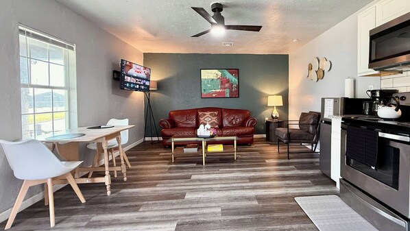Relax in a stylish lounge with a smart TV, full kitchen, and comfy leather seating—perfect for unwinding after a day of exploring.