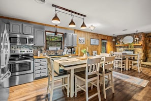 Cook up a feast in this rustic-modern kitchen with stainless steel appliances and farmhouse-style dining.