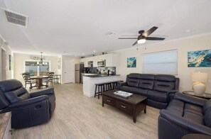 Spacious living with plush rocker recliners, leather sofas, and a full view of the open layout.