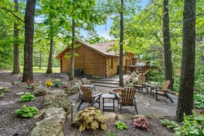 Tucked among the trees, this cozy forest courtyard with a fire pit invites guests to unwind, reconnect, and enjoy the rustic charm of cabin living