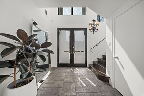 Step into a light-filled front entry, bathed in natural light from large windows
