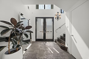 Step into a light-filled front entry, bathed in natural light from large windows
