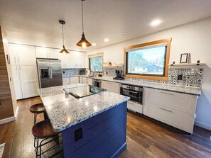 A stocked kitchen with a fridge, microwave, electric range and oven. We also provide the basics such as salt, pepper, cooking oil.