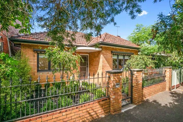 FRONT: Wide, double fronted home with three bedrooms (Queen, Queen Twin Single) in a tree lined street. Parking directly out front.
