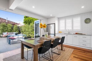 MEALS: The meals area with stylish wood table that comfortably seats 6 opens to the sunny courtyard.
