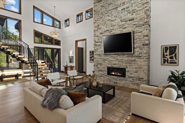 Cozy modern living room with stone hearth and sleek flame feature fireplace