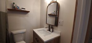 Powder Room: Elegant design with a chic mirror and sleek counter for a refreshing stay!