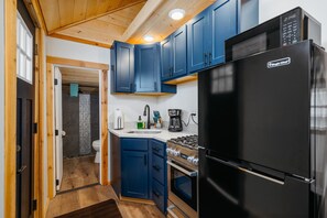 Sleek navy cabinetry, modern appliances, and bright lighting for delightful culinary adventures!