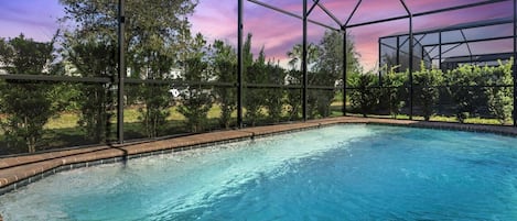 Backyard Patio | Private, screened, heated pool is surrounded by privacy hedges.